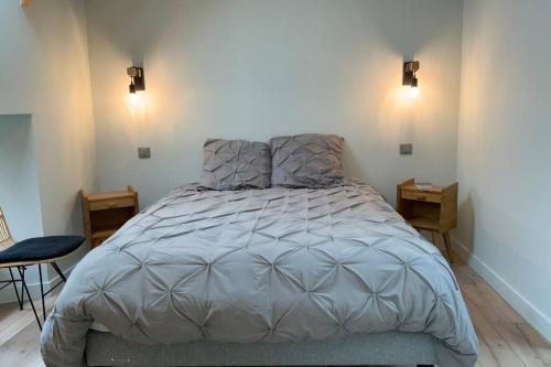 a large bed in a room with two night stands at Maison près de la Pointe du Raz in Plogoff