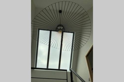 a spiral staircase with a large window at Maison près de la Pointe du Raz in Plogoff