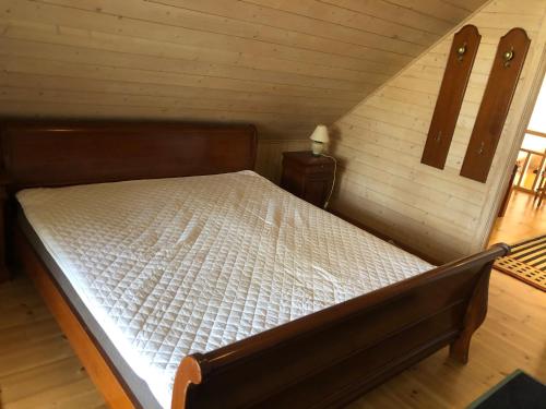a bedroom with a bed in a wooden room at Sävekulla 207 "Brygghuset" in Älvsered