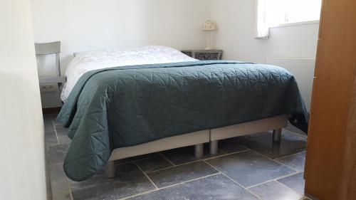 1 dormitorio con 1 cama con edredón verde en Hemels paradijs in La Roche en Ardenne te Cielle, en La-Roche-en-Ardenne