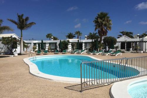 a large swimming pool in a resort with palm trees at Bandama 15 2 Bedroom Ground Floor in Los Pocillos