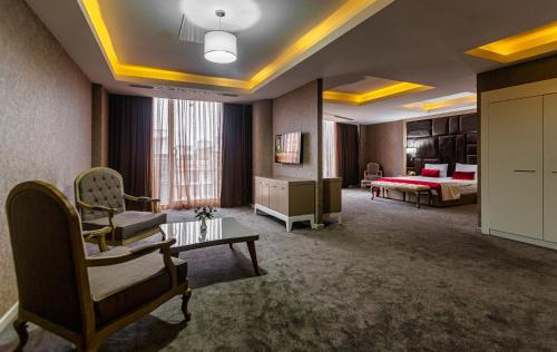 a hotel room with a bed and a living room at Sky Hotel Baku in Baku