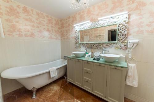 a bathroom with a tub and a sink and a mirror at Rey Don Pedro Luxury Home in Seville