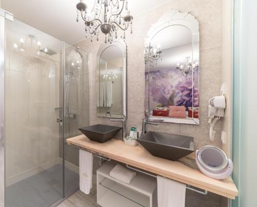 a bathroom with two sinks and a glass shower at Rey Don Pedro Luxury Home in Seville