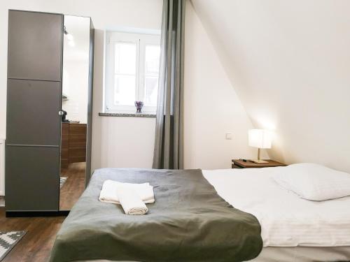 a bedroom with a bed with a towel on it at ✰Mansarda na Białoskórniczej✰5 minut od Rynku in Wrocław
