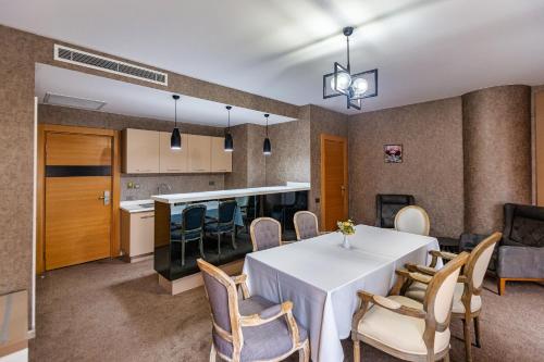 a dining room with a white table and chairs at Sky Hotel Baku in Baku
