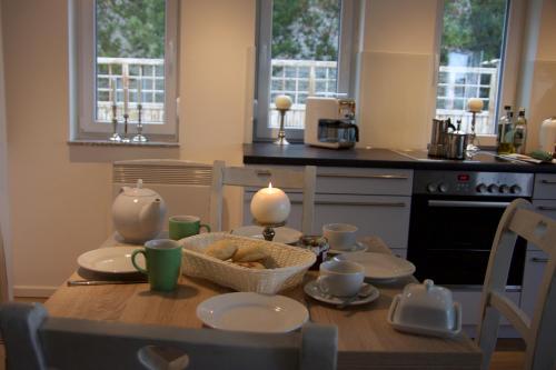a kitchen with a wooden table with plates and cups at Ferienhaus-Achterwasser-Usedom in Rankwitz
