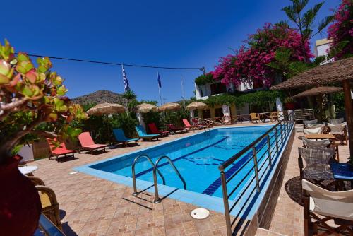 a large swimming pool with chairs and umbrellas at Galissas Studios in Galissas