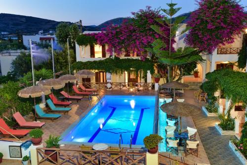 an outdoor swimming pool with chairs and umbrellas at Galissas Studios in Galissas