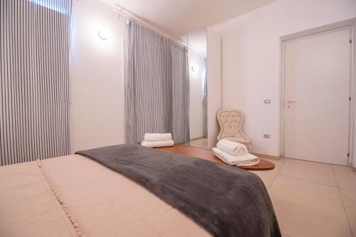 a bedroom with a bed and a chair in it at Holiday Fontane Bianche Gabriella in Fontane Bianche