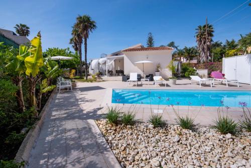 eine Villa mit einem Pool und einem Haus in der Unterkunft Holiday Fontane Bianche Gabriella in Fontane Bianche