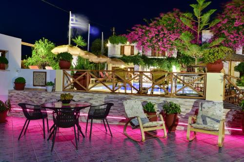 a table and chairs on a patio with pink lights at Galissas Studios in Galissas