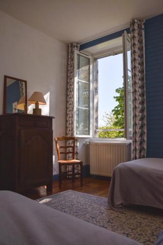 une chambre avec un lit, une fenêtre et une chaise dans l'établissement Utah Beach Chambre hote, à Sainte-Marie-du-Mont
