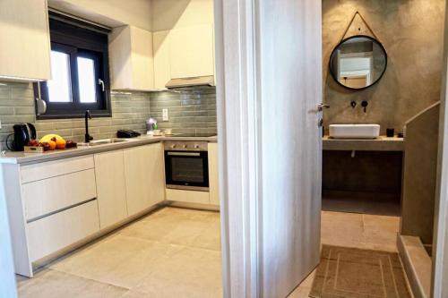 a kitchen with white cabinets and a mirror at Havana 2 Luxury sea and pool in Gázion