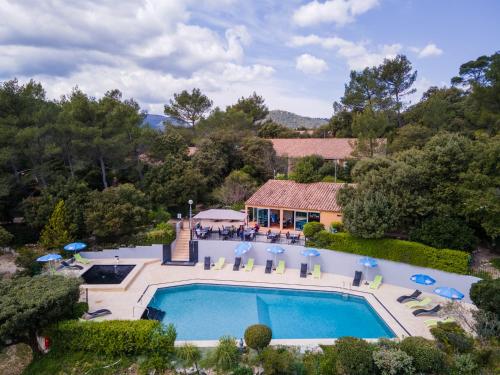 eine Luftansicht eines Hauses mit Pool in der Unterkunft Les Arbousiers Village Hôtel Provençal in La Roquebrussanne