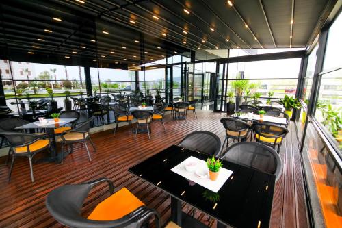a restaurant with tables and chairs on a deck at N Hotel BY NOSHI in Rinas
