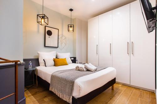 - une chambre avec un lit et des armoires blanches dans l'établissement very cozy 2p Louvre--Orsay-- saint-germain-des-pres, à Paris