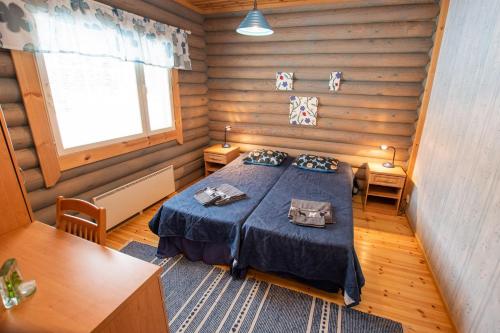 1 dormitorio con 1 cama en una habitación de madera en Villa Mertala, en Pääjärvi