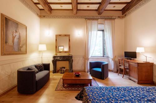 a living room with a bed and a desk at Castello di Baccaresca in Branca