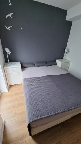 una camera con un letto con una parete viola di Apartament Vespa a Mechelinki