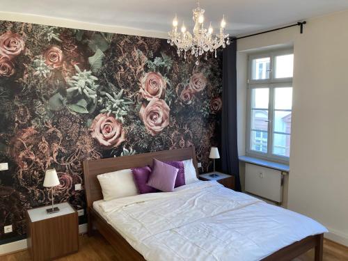 1 dormitorio con 1 cama con pared de flores en Café & Hotel Knösel en Heidelberg