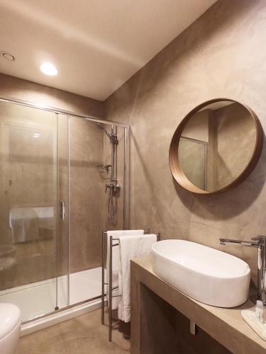a bathroom with a sink and a shower and a mirror at BeA Guest House in Porto Ercole