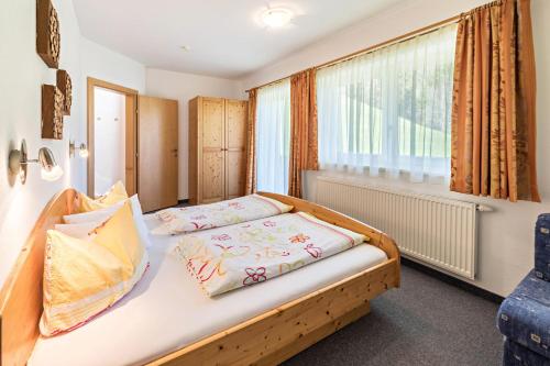 een slaapkamer met een bed en een raam bij Ferienwohnung Jakob in Schwendau