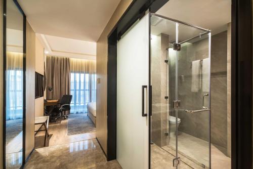 een glazen douchedeur in een hotelkamer bij Aber Al Takhassusi in Riyad