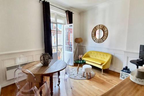 un salon avec un canapé jaune et une table dans l'établissement Beau 2 pièces en centre ville et à 200m de la mer, à Cabourg