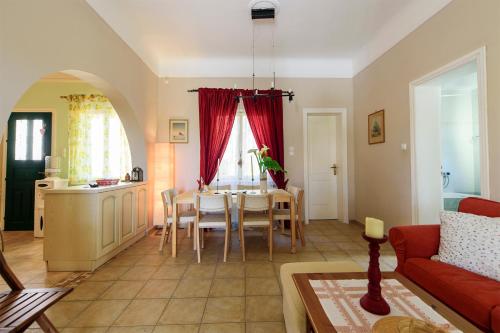 a living room with a red couch and a table at JASMINE OF POSEIDONIA in Posidhonía
