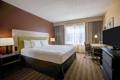 a hotel room with a bed and a desk and a computer at Comfort Inn & Suites St Paul Northeast in Vadnais Heights