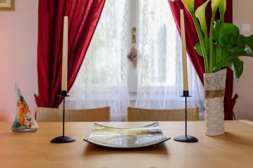 a table with two candles and a plate on it at JASMINE OF POSEIDONIA in Posidhonía