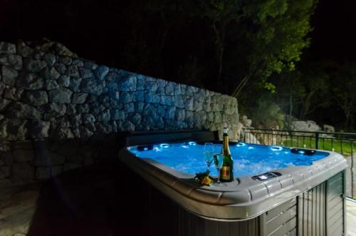 a bath tub with a bottle of wine in it at Villa Falcon Rook in Gruda