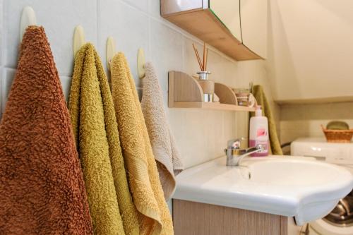 a bathroom with towels hanging next to a sink at JASMINE OF POSEIDONIA in Posidhonía