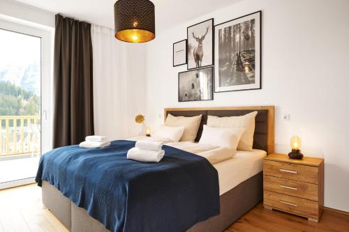 ein Schlafzimmer mit einem Bett mit einer blauen Decke in der Unterkunft Adler Lodge D5 in Tauplitz