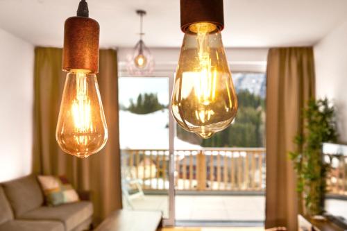 a living room with three lights hanging from the ceiling at Adler Lodge D5 in Tauplitz