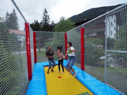 eine Gruppe von Frauen, die auf einem Trampolin im Innenbereich spielen in der Unterkunft Zugspitz-Arena Fewo Haus Schachtkopf in Biberwier