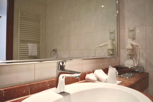 ein Bad mit einem Waschbecken und einem Spiegel in der Unterkunft Hotel Alter Packhof in Hannoversch Münden