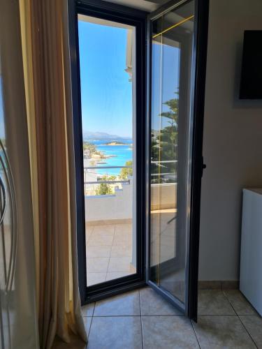 a sliding glass door with a view of the ocean at Hotel Ardiani in Ksamil