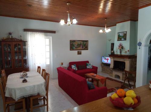 a living room with a red couch and a table at Villa Olive Garden, Kastanida - Paxoi in Gaios
