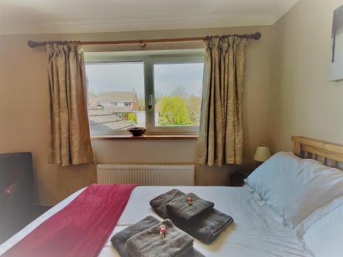a bedroom with a bed with two towels on it at Nant Gloyw Oswestry in Oswestry