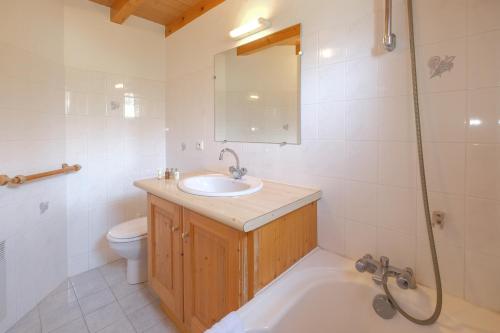 a bathroom with a sink and a tub and a toilet at Chalet Himalaya , 10 Person Chalet with 5 ensuite bedrooms and outdoor jacuzzi in Meribel Centre in Méribel