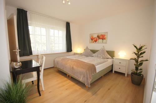 a bedroom with a bed and a desk and a window at Ferienhaus I Weitblick in Grömitz
