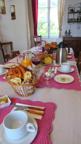 uma mesa com uma toalha de mesa com comida e uma chaleira. em Le Clos Joséphine em Saint-Dyé-sur-Loire