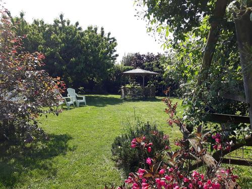 un jardín con cenador, silla y flores en Le Clos Joséphine en Saint-Dyé-sur-Loire