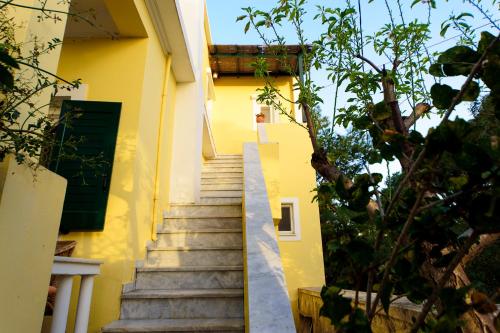 a stairway leading up to a yellow building at JASMINE OF POSEIDONIA in Posidhonía