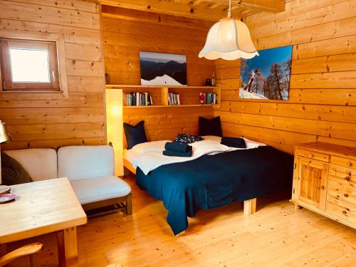 a bedroom with a bed and a chair in a cabin at Haus Liesenfeld in Gosau