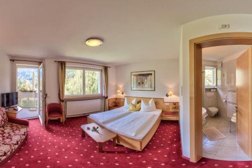 a hotel room with a bed and a couch at Appartement Hotel Erlhof Deluxe in Lutago