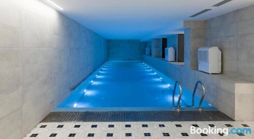 La salle de bains est pourvue d'une piscine avec un éclairage bleu. dans l'établissement Parilament on Rustaveli 4 rooms, à Tbilissi
