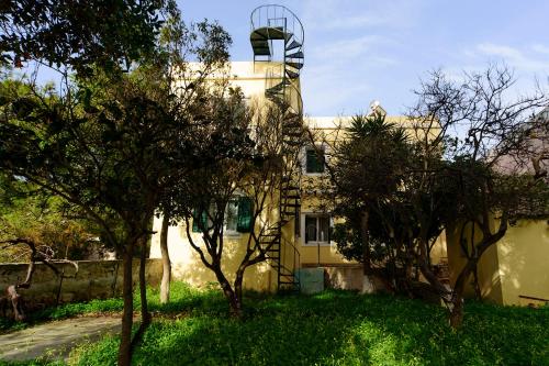 a building with a spiral staircase on the side of it at JASMINE OF POSEIDONIA in Posidhonía